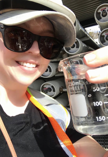 Caty Wagner holds up a beaker of recycled water
