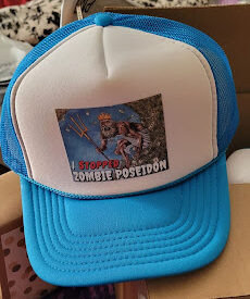 A blue and white mesh hat reads - I stopped zombie poseidon